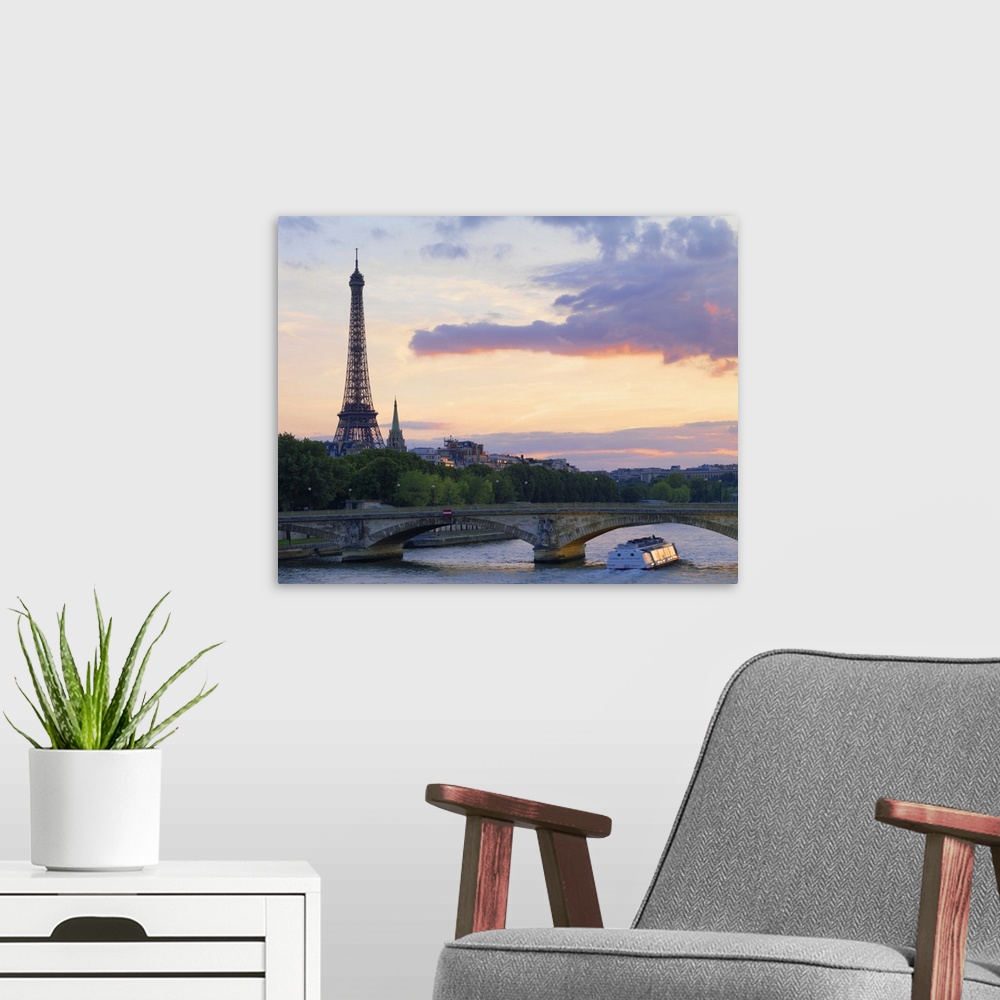 A modern room featuring France,Paris,tour boat on River Seine,Eiffel Tower behind at dusk