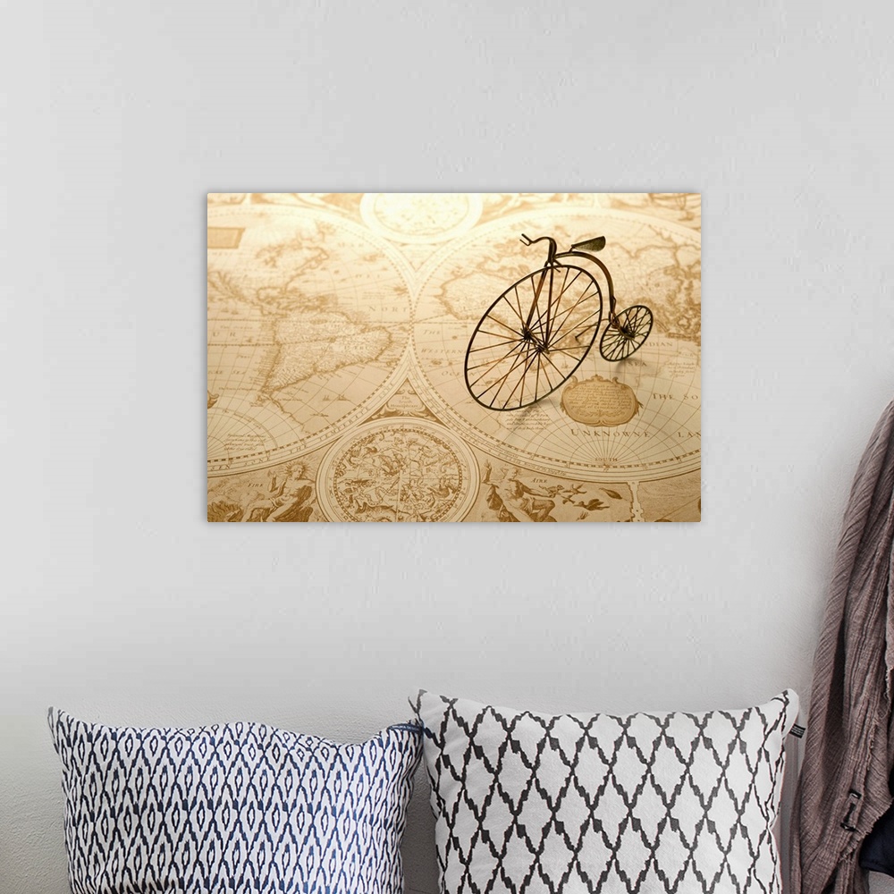 A bohemian room featuring An antique toy bike on top of an old map of the world.