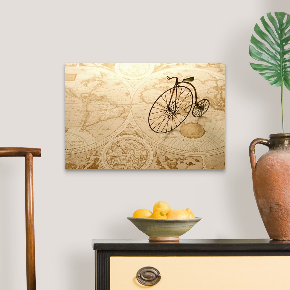 A traditional room featuring An antique toy bike on top of an old map of the world.