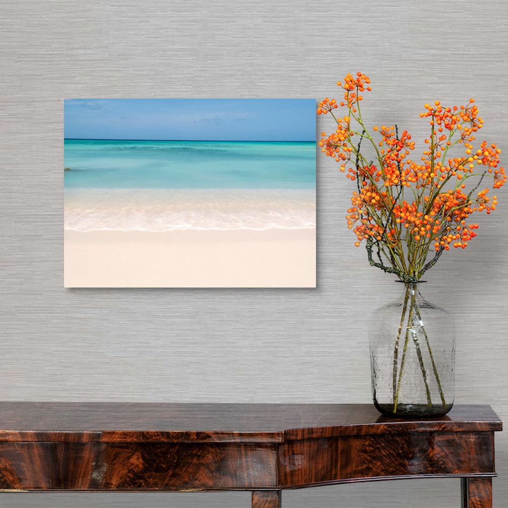 A traditional room featuring Horiztonal wall art of a serene beach and a still sea on a clear day in Aruba.