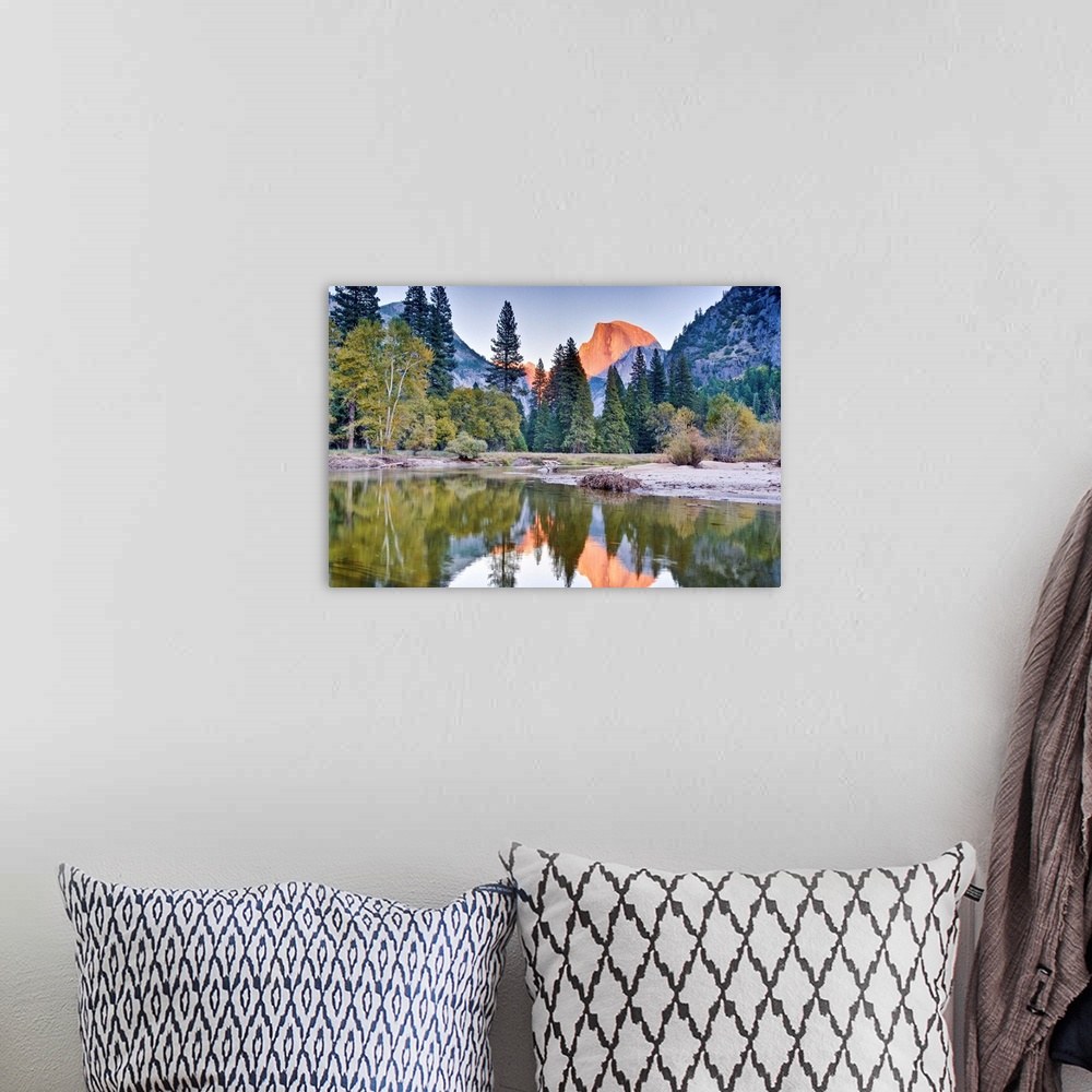 A bohemian room featuring Trees and mountain reflection in river.