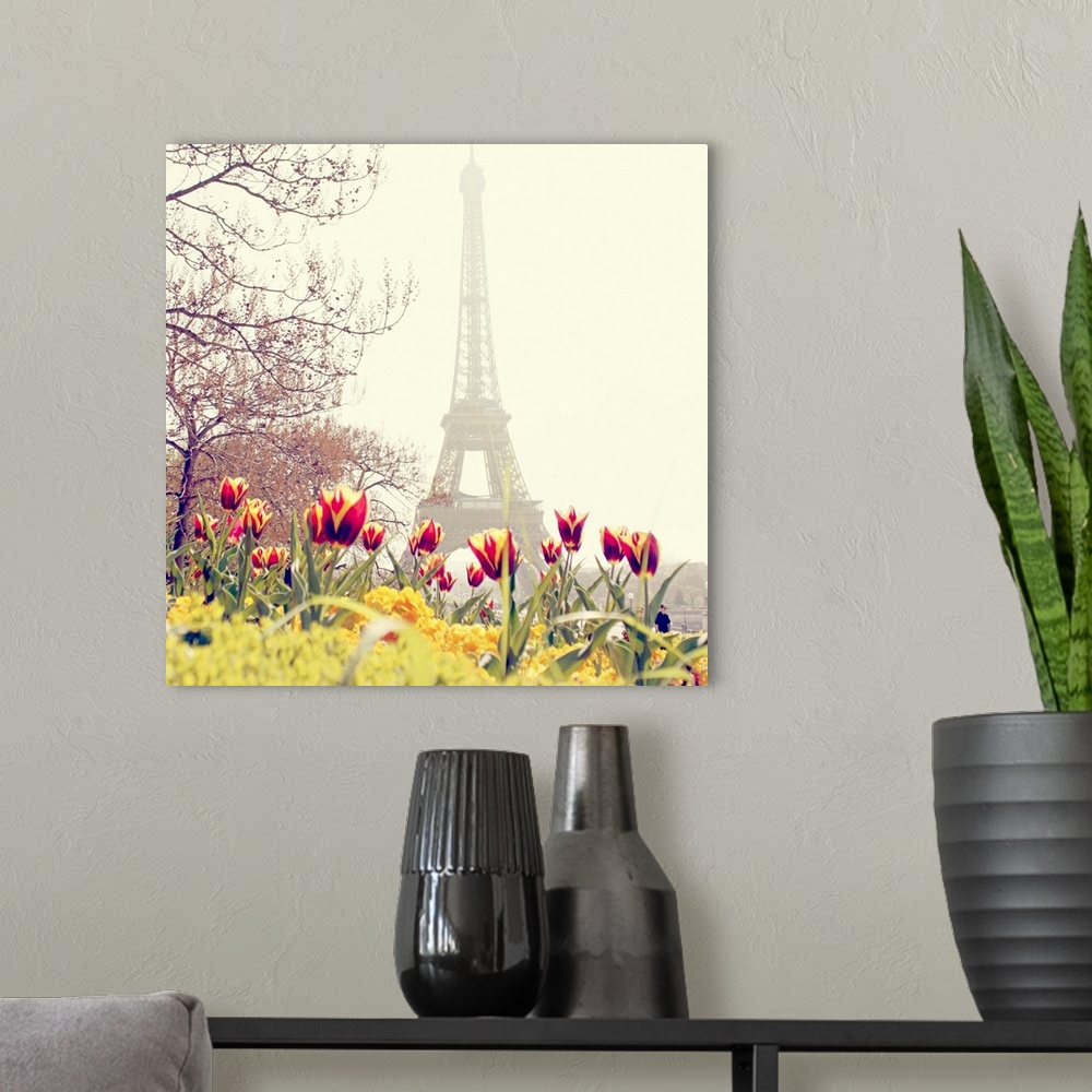 A modern room featuring Low angle photograph of the Eiffel Tower in the background with tulip blossoms and trees in the f...