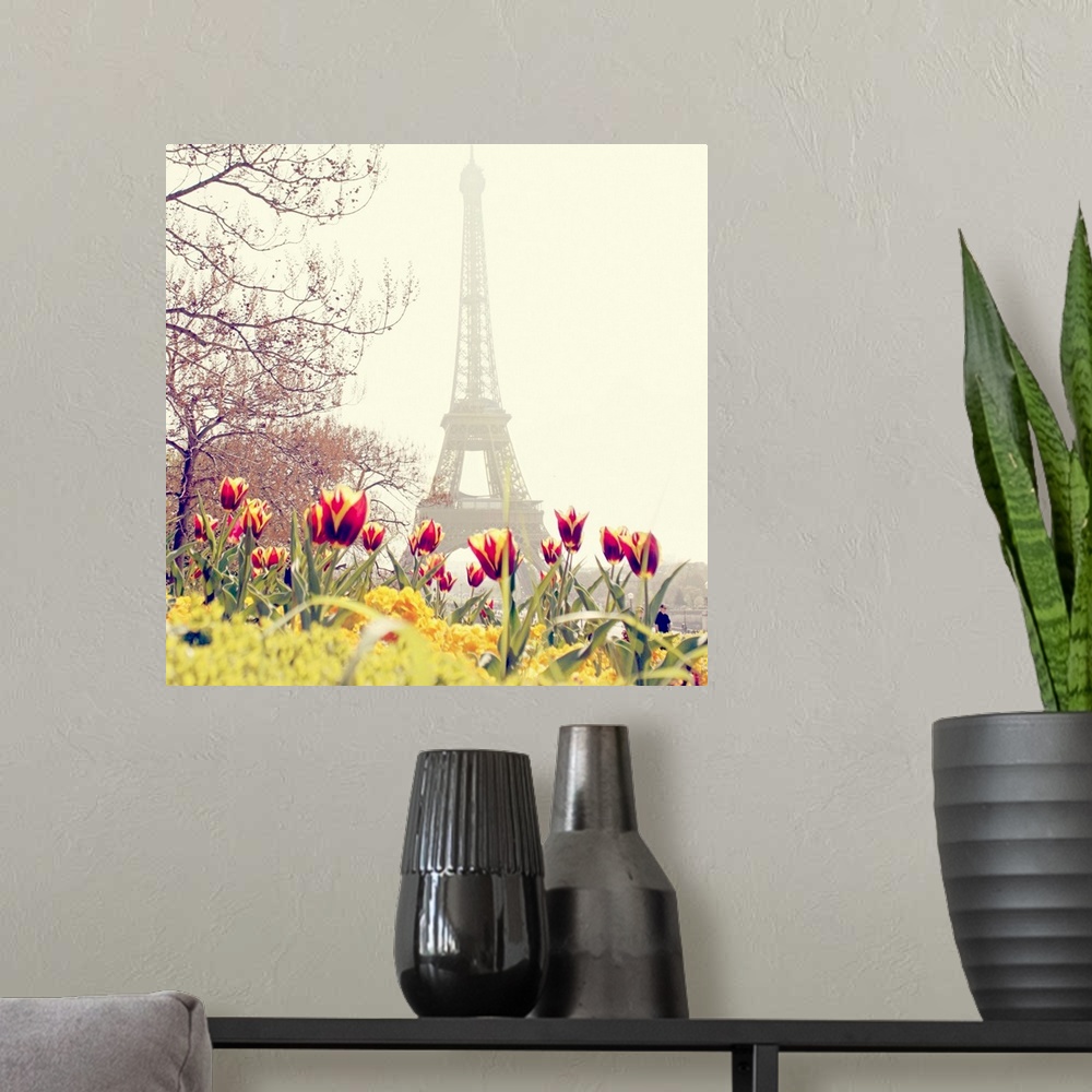 A modern room featuring Low angle photograph of the Eiffel Tower in the background with tulip blossoms and trees in the f...