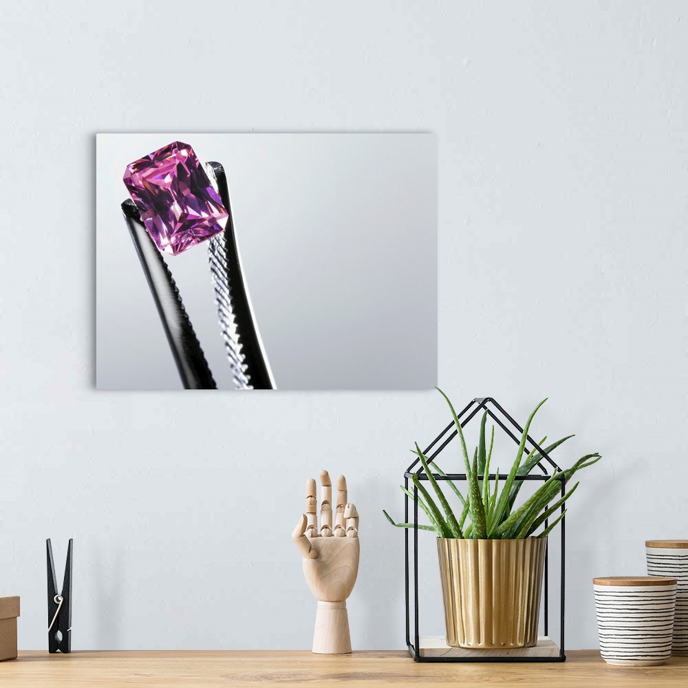 A bohemian room featuring Tweezers holding small purple gem, close-up
