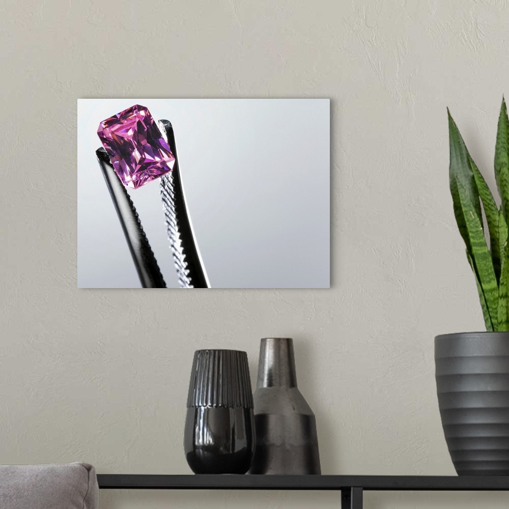 A modern room featuring Tweezers holding small purple gem, close-up