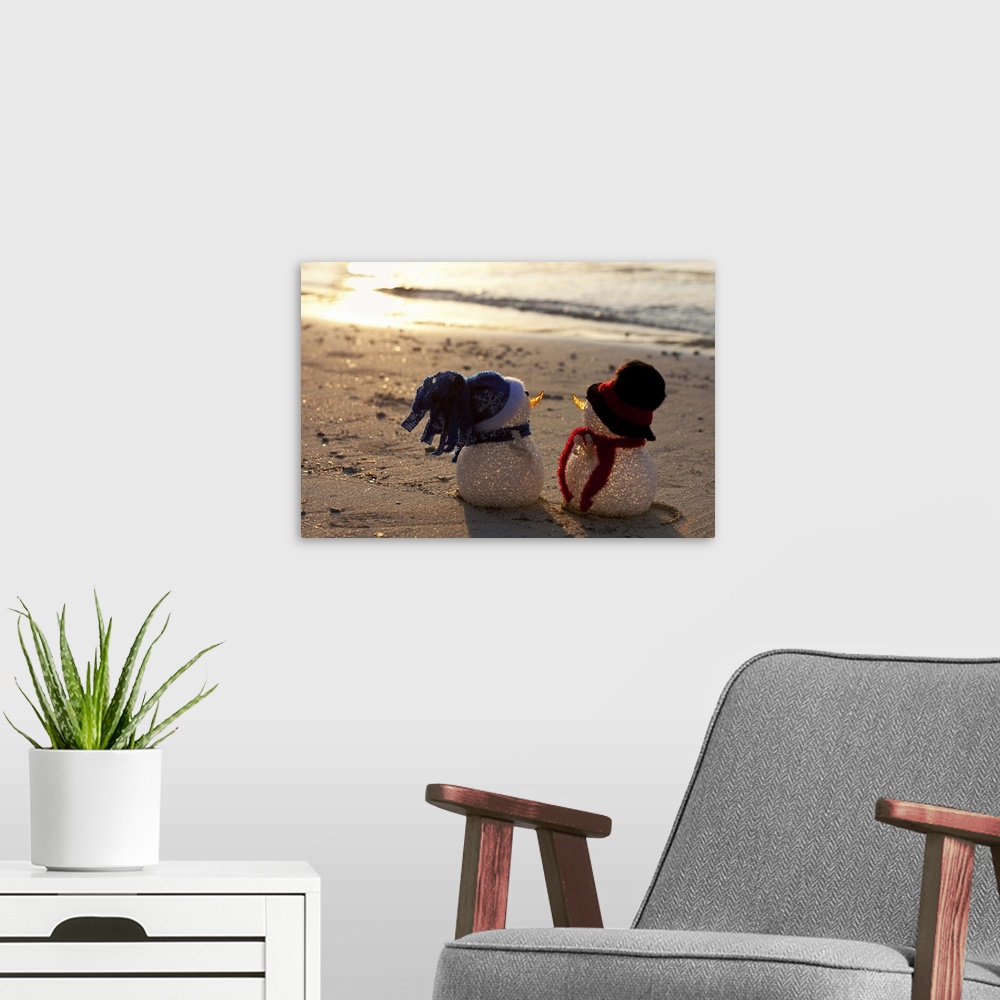 A modern room featuring Two snowmen look to the sea at sunset. White sand and waves in the background. View from behind. ...