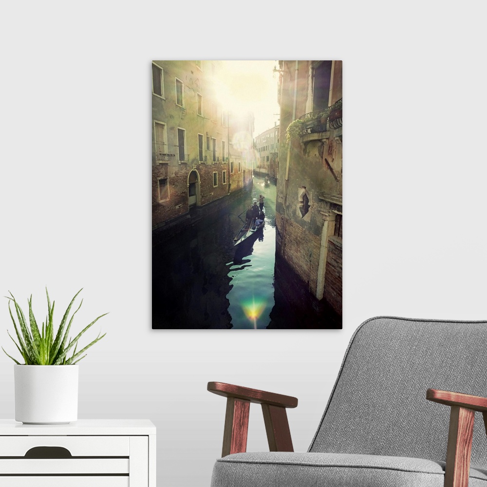 A modern room featuring Portrait, oversized photograph of two gondolas floating toward the bright sun, through a canal in...