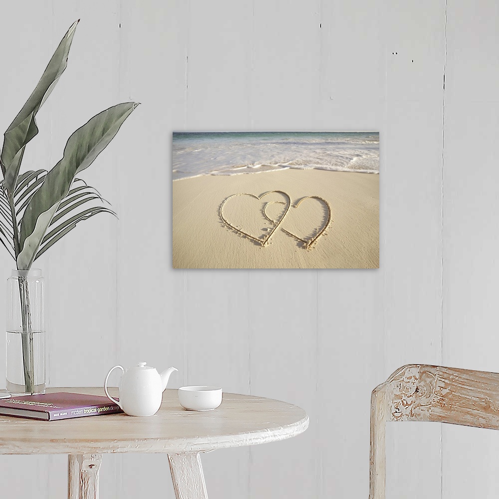 A farmhouse room featuring Two overlying hearts drawn on the beach with incoming surf.