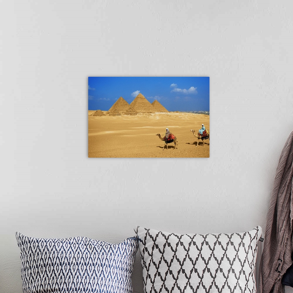 A bohemian room featuring Two people riding camels near the pyramids of Giza, Egypt