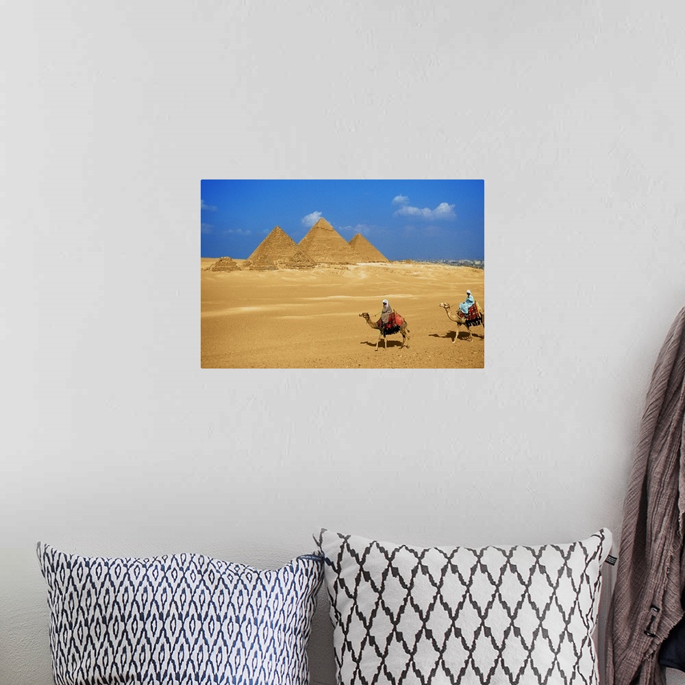 A bohemian room featuring Two people riding camels near the pyramids of Giza, Egypt