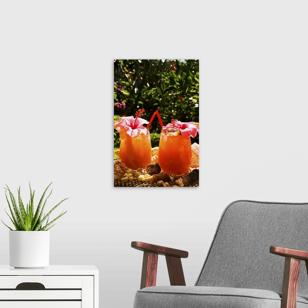 A modern room featuring Two tropical drinks garnished with flowers in an outdoor setting.