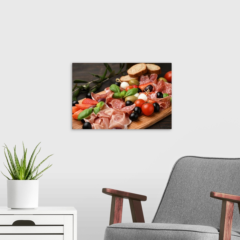 A modern room featuring Typical antipasto in an Italian restaurant salami, ham prosciutto, with green and black olives, a...