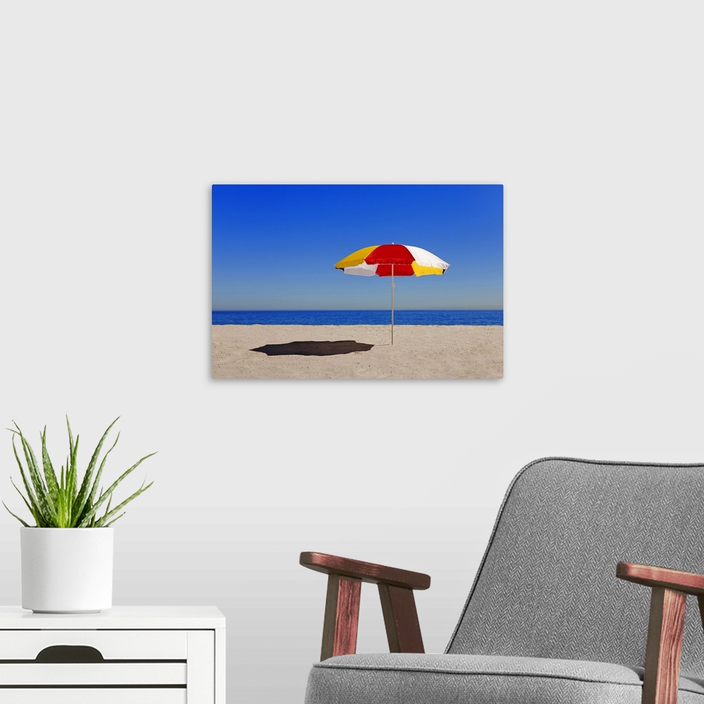 A modern room featuring Umbrella in sand on empty beach