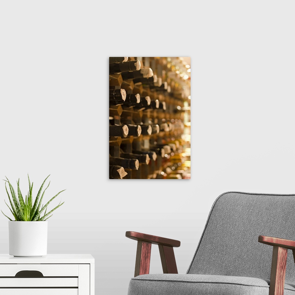 A modern room featuring Artwork perfect for the home of wine bottles stacked in cellar shelves. Taken at an angle so only...