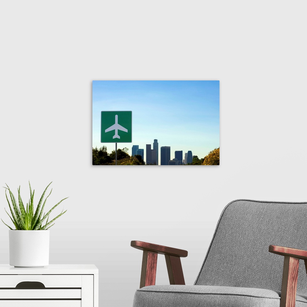 A modern room featuring USA, California, Los Angeles, airport sign with city skyline in background