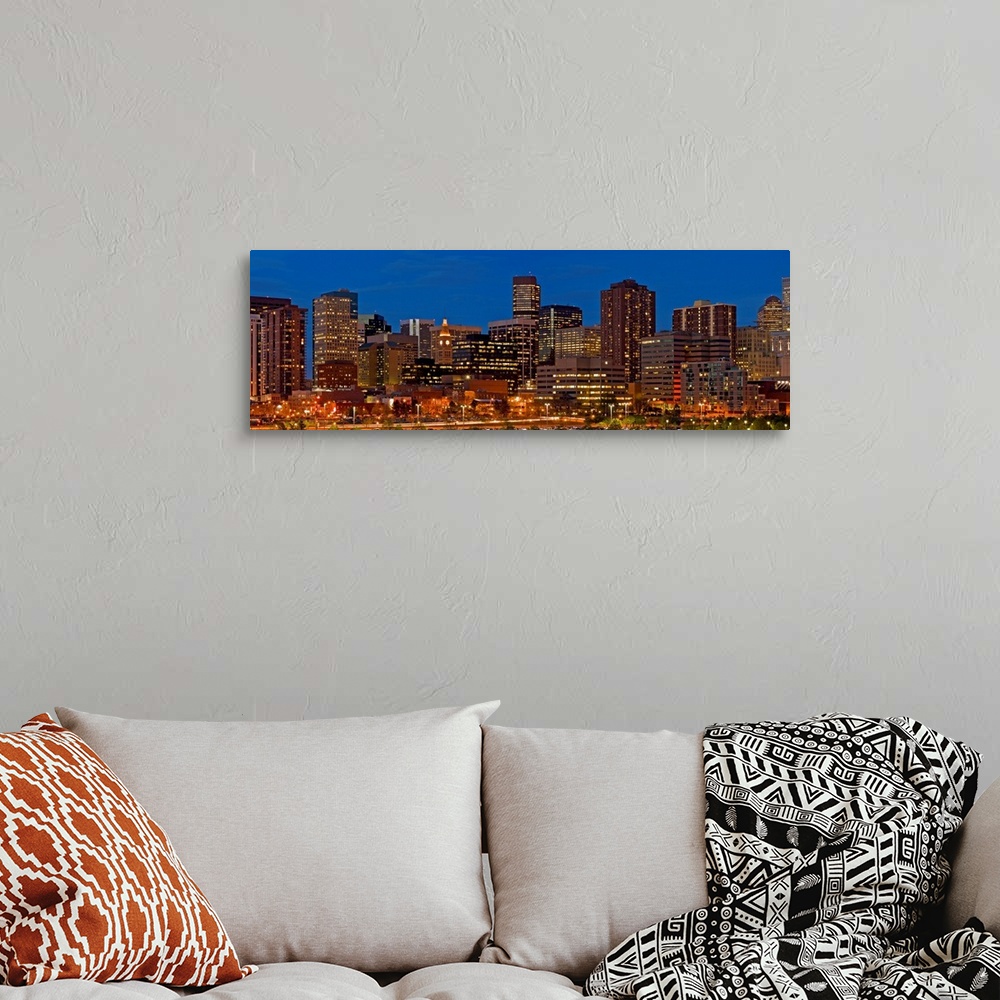 A bohemian room featuring Panoramic photograph of lit up skyline under a clear sky.