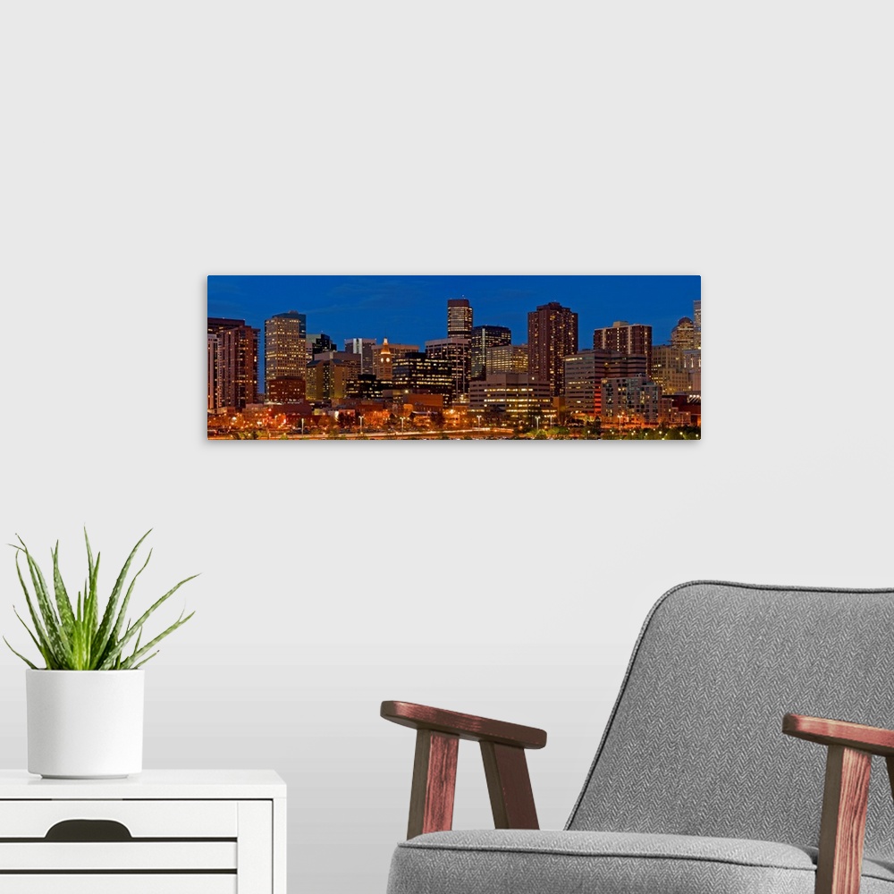 A modern room featuring Panoramic photograph of lit up skyline under a clear sky.
