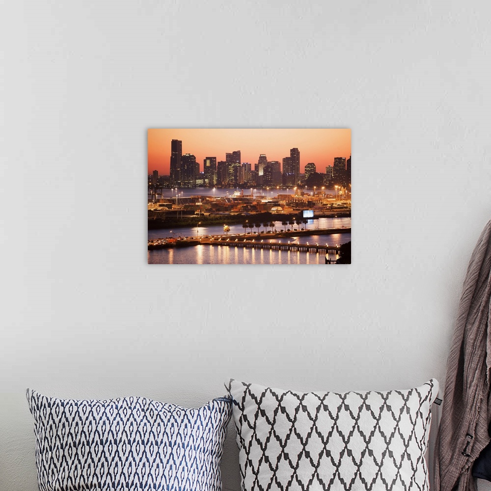 A bohemian room featuring Photograph of skyline and waterfront with buildings lit up at dusk.