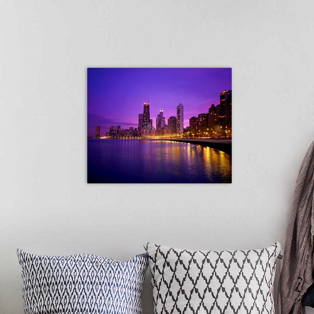 A bohemian room featuring Photograph of cityscape and waterfront at night.  The buildings are lit up and the lights are ref...