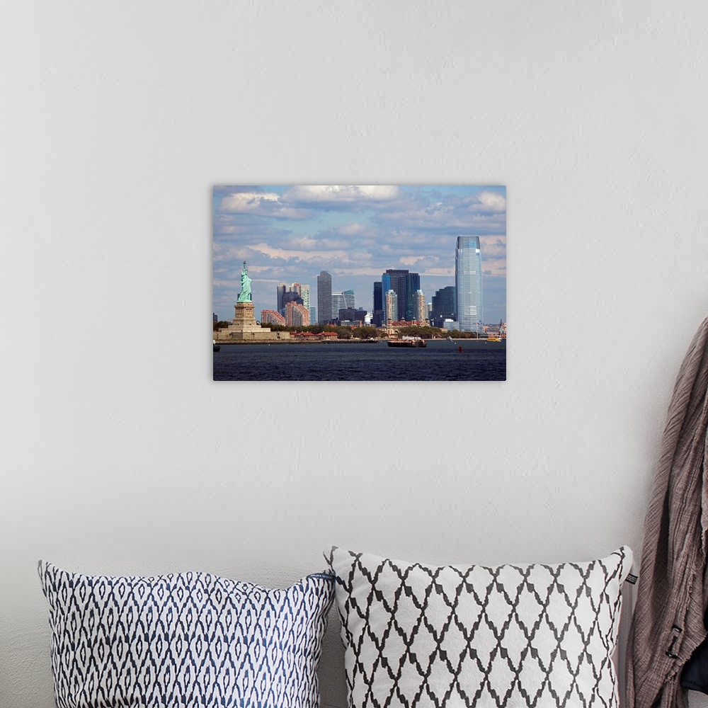 A bohemian room featuring The Statue of Liberty and the NYC skyline are photographed under a cloudy sky.