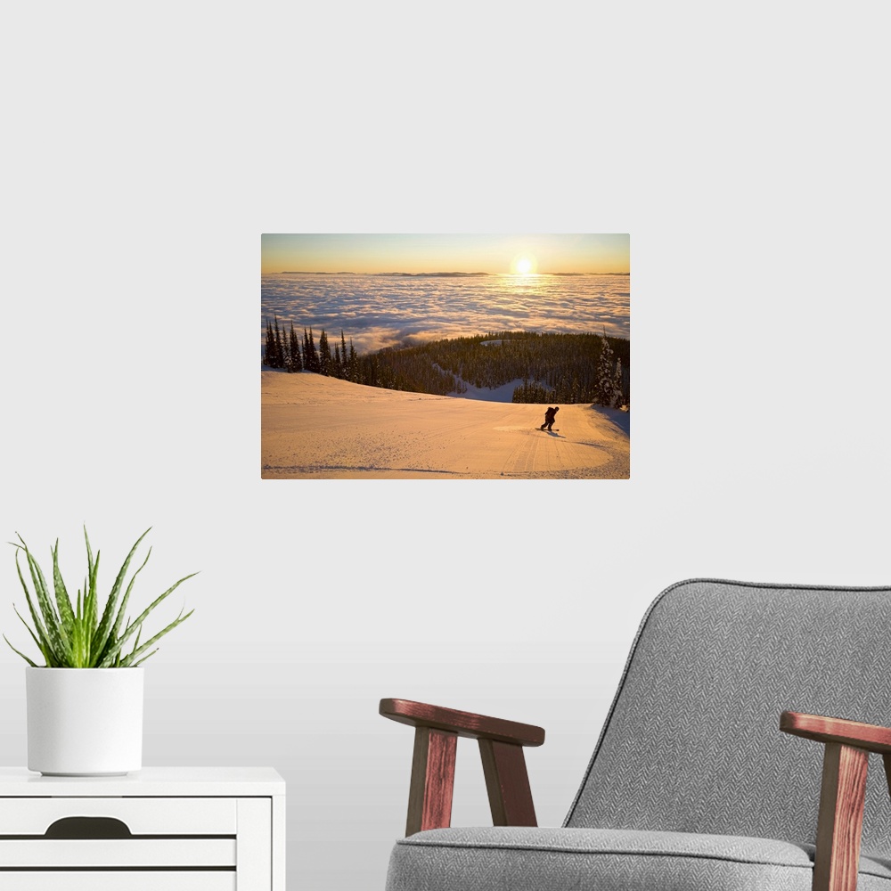 A modern room featuring Oversized horizontal photograph of a man snowboarding down a hill that is high above a winter lan...