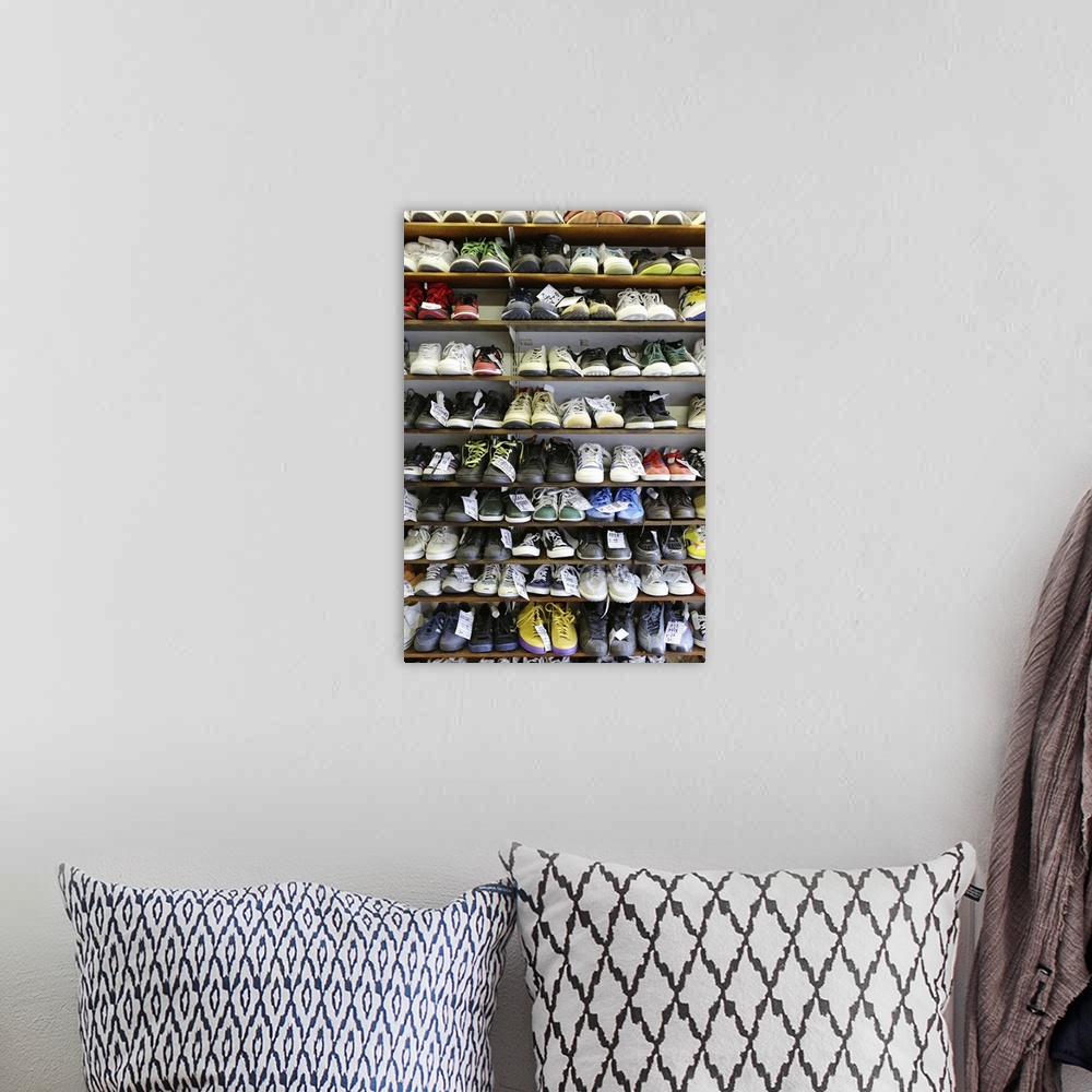 A bohemian room featuring Various types of second hand trainers and casual footwear arranged on shelves.