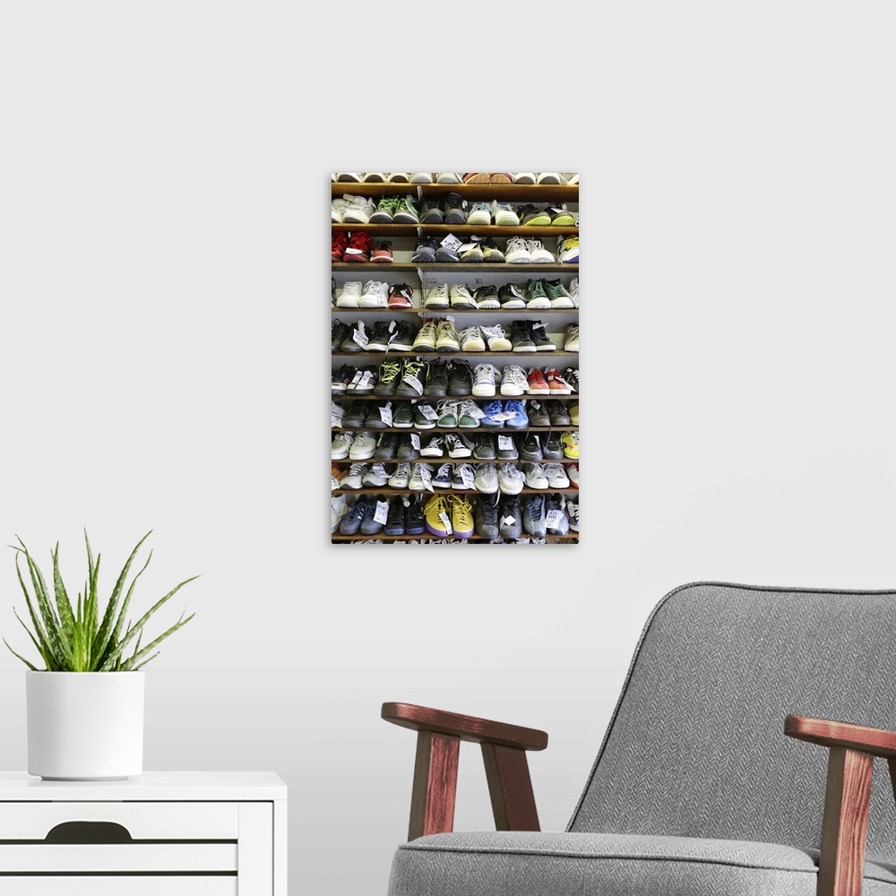 A modern room featuring Various types of second hand trainers and casual footwear arranged on shelves.