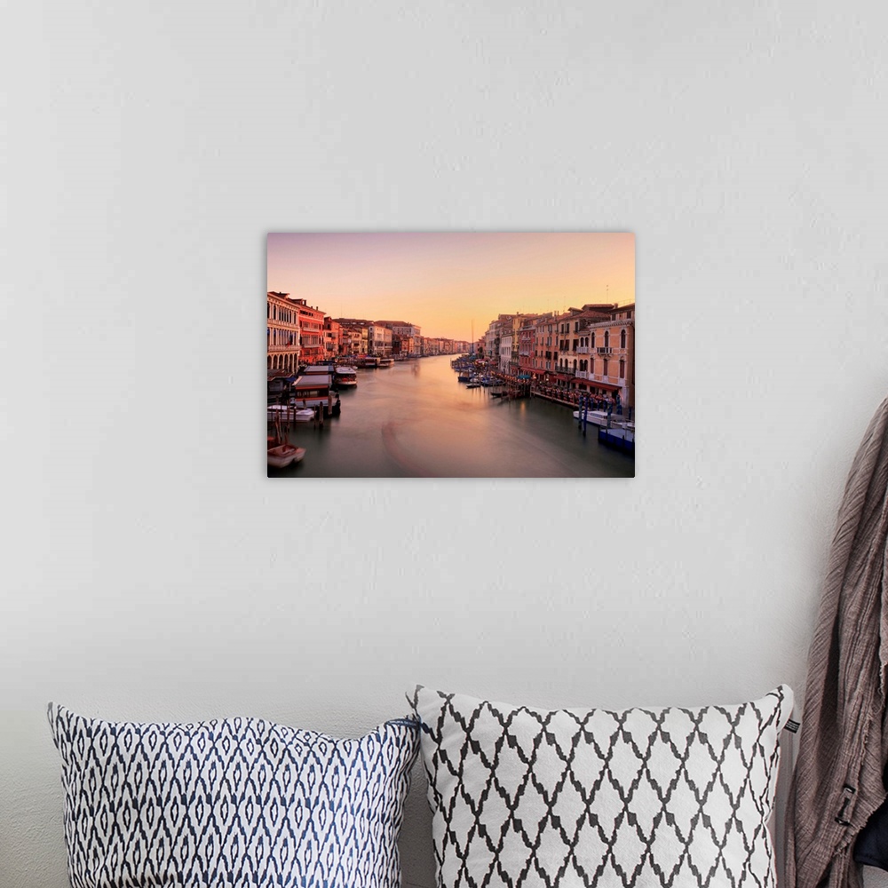 A bohemian room featuring Venetian canal side palaces around Rialto Bridge glow in last of evening light.