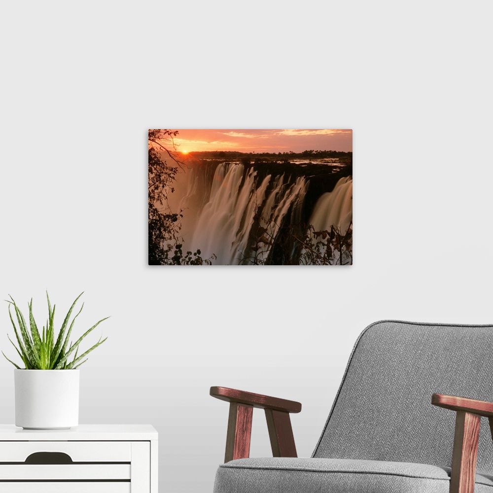 A modern room featuring Victoria Falls with sun on horizon, Victoria Falls, Zimbabwe