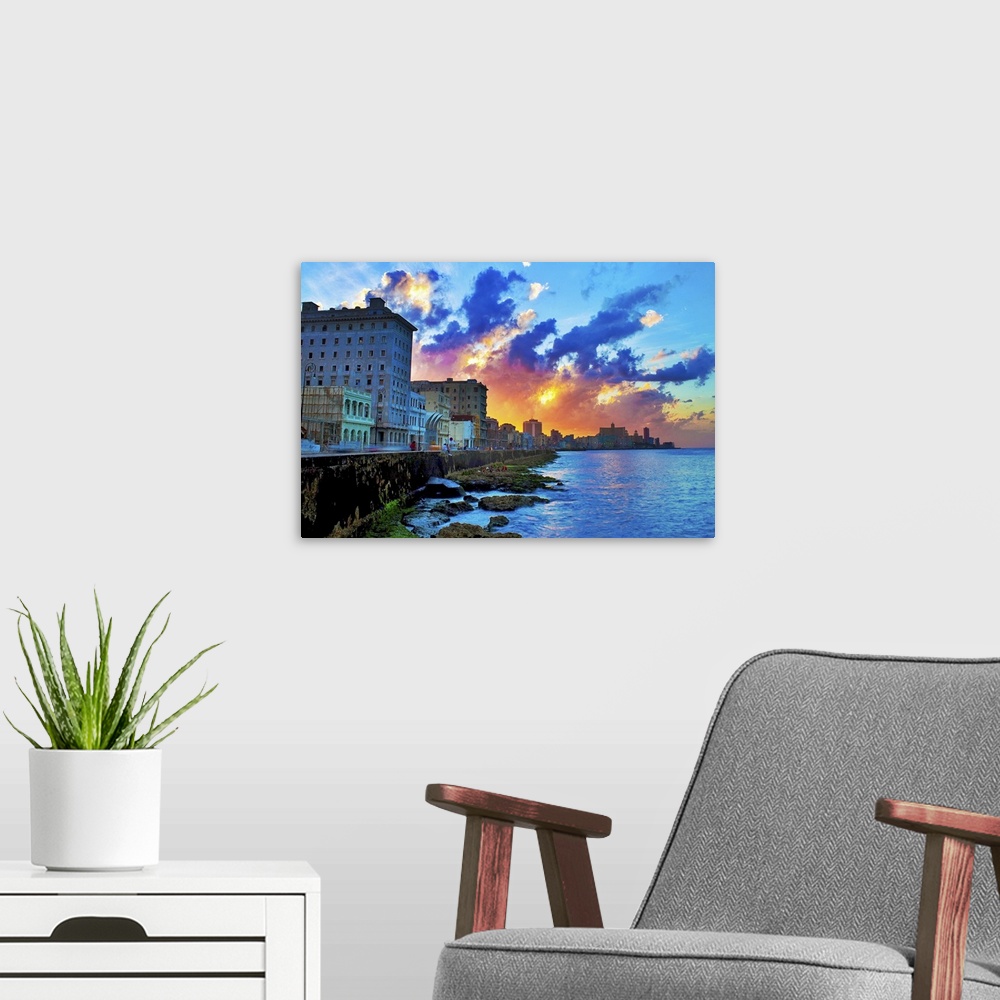 A modern room featuring View of buildings and sea during sunset in Cuba.