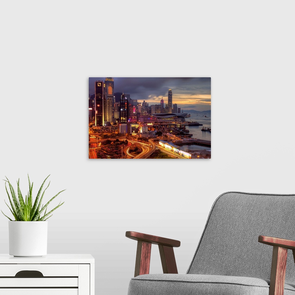 A modern room featuring Big landscape photograph of winding roads lading around and through the city of Hong Kong.  Skysc...