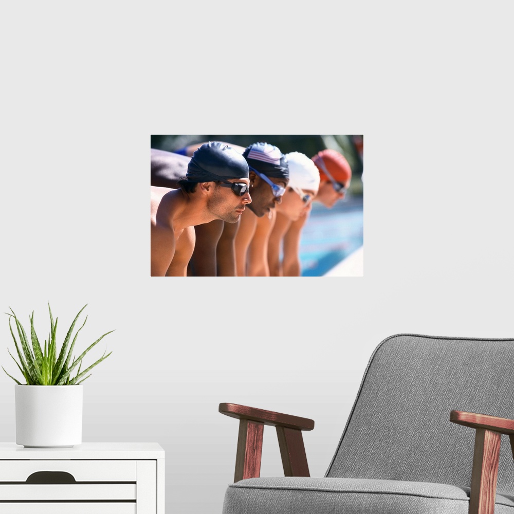 A modern room featuring view of male swimmers at the start of a race