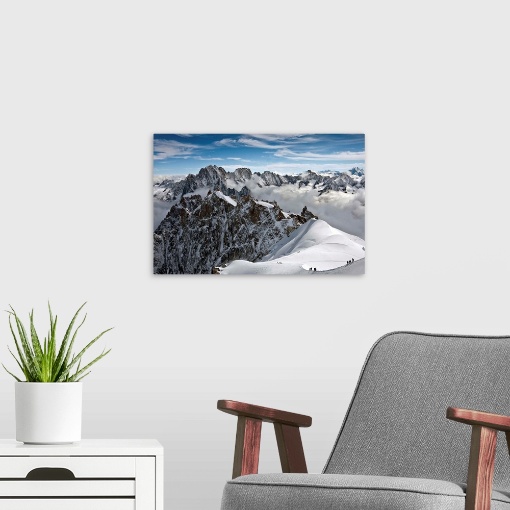 A modern room featuring View of Mont Blanc massif in French Alps, with alpine climbers in snow, France.