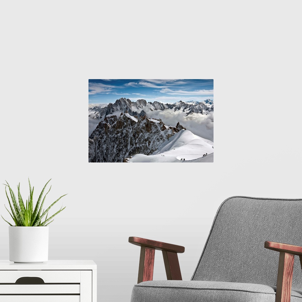 A modern room featuring View of Mont Blanc massif in French Alps, with alpine climbers in snow, France.