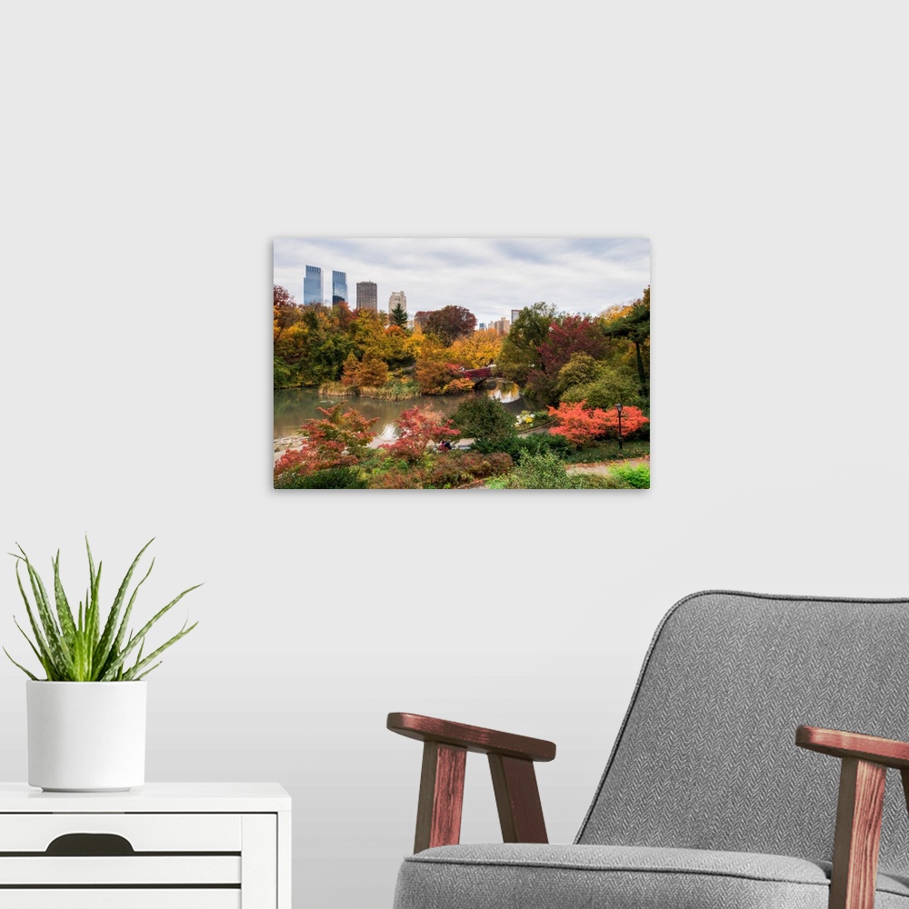 A modern room featuring View of the Central Park Pond and the New York skyline. The foliage is at peak color.