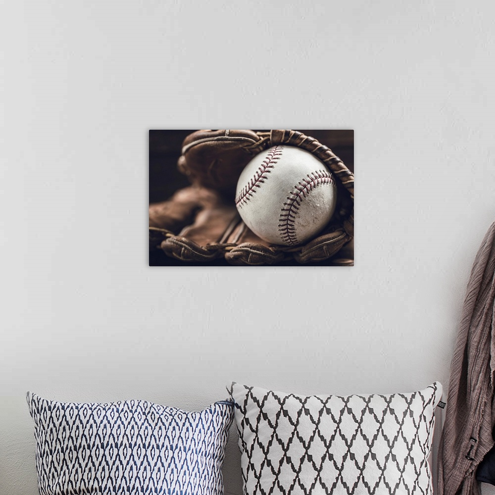 A bohemian room featuring A group of vintage baseball equipment, bats, gloves, baseballs on wooden background.
