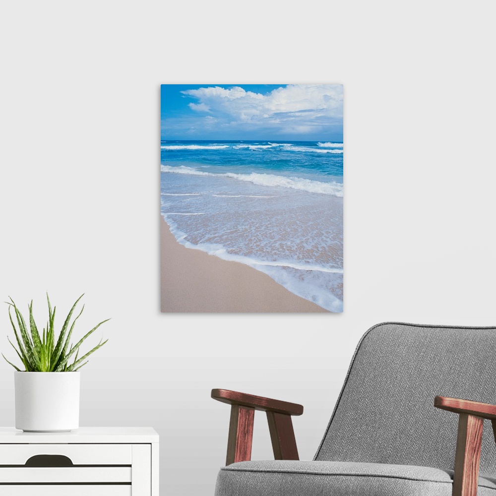 A modern room featuring Photograph of small waves lapping on the white sandy beach.