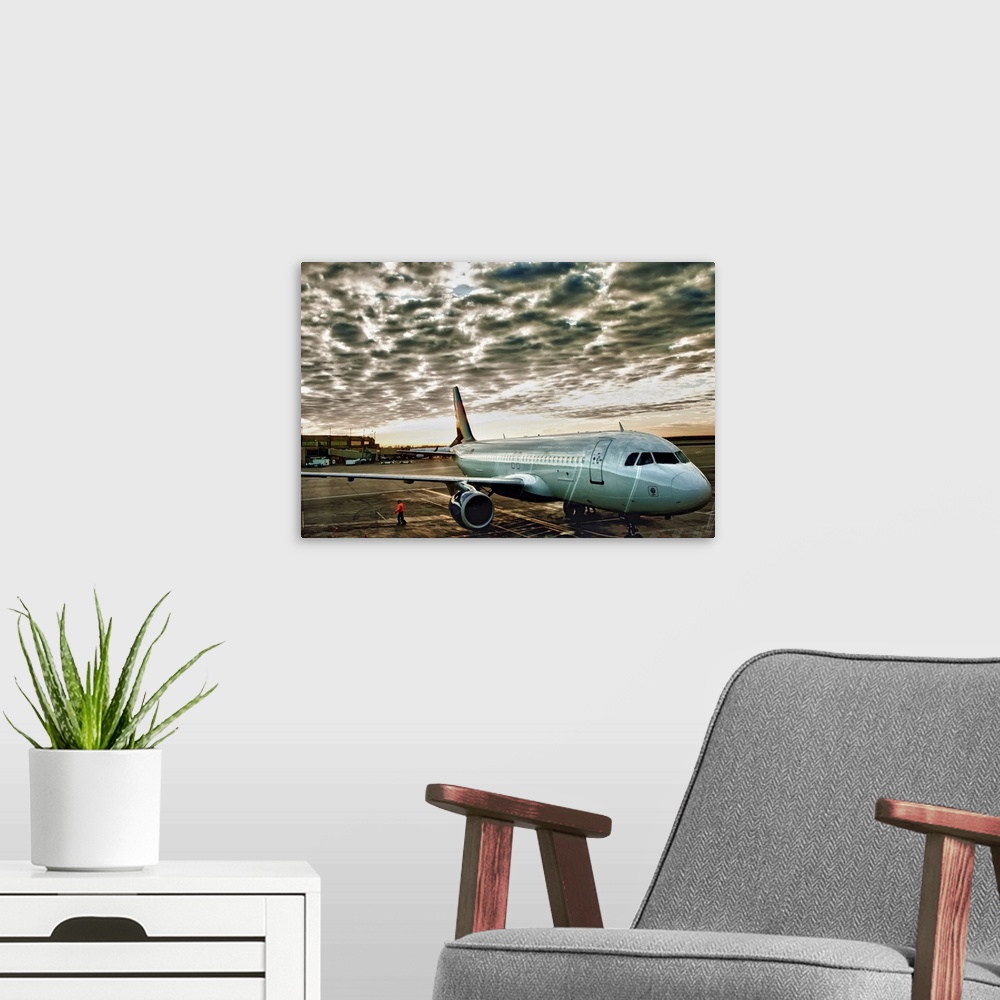 A modern room featuring Airport daybreak shot of plane waiting to depart as storm clouds pass overhead.