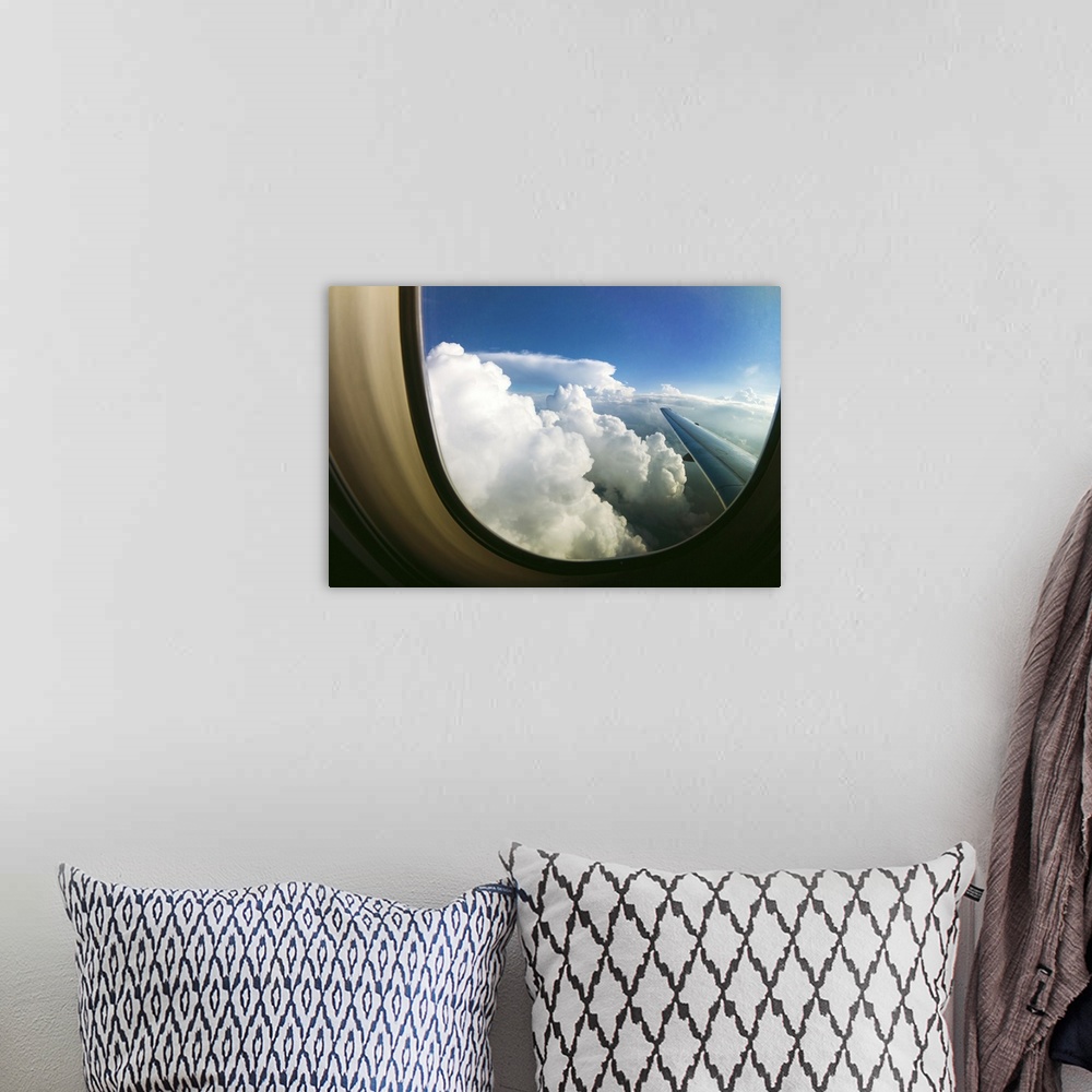 A bohemian room featuring White fluffy clouds looking through airplane window.