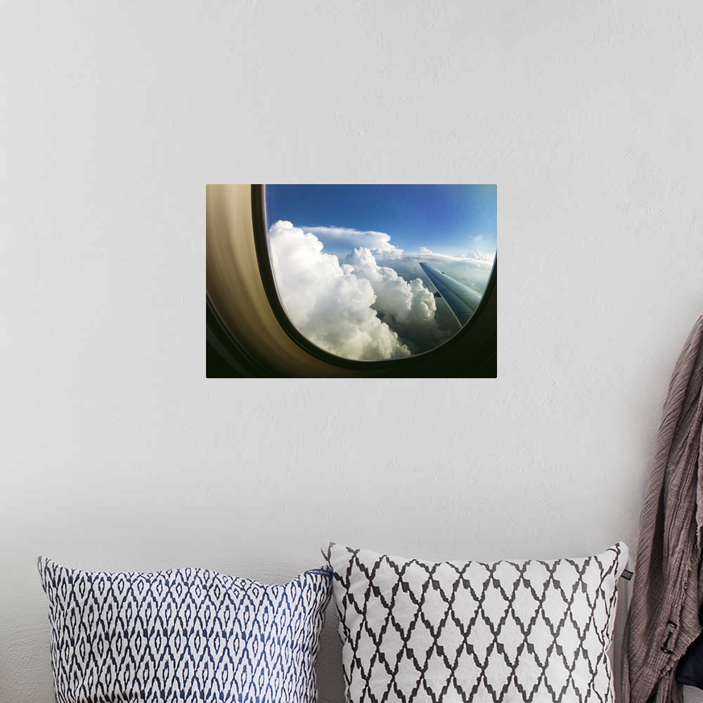 A bohemian room featuring White fluffy clouds looking through airplane window.