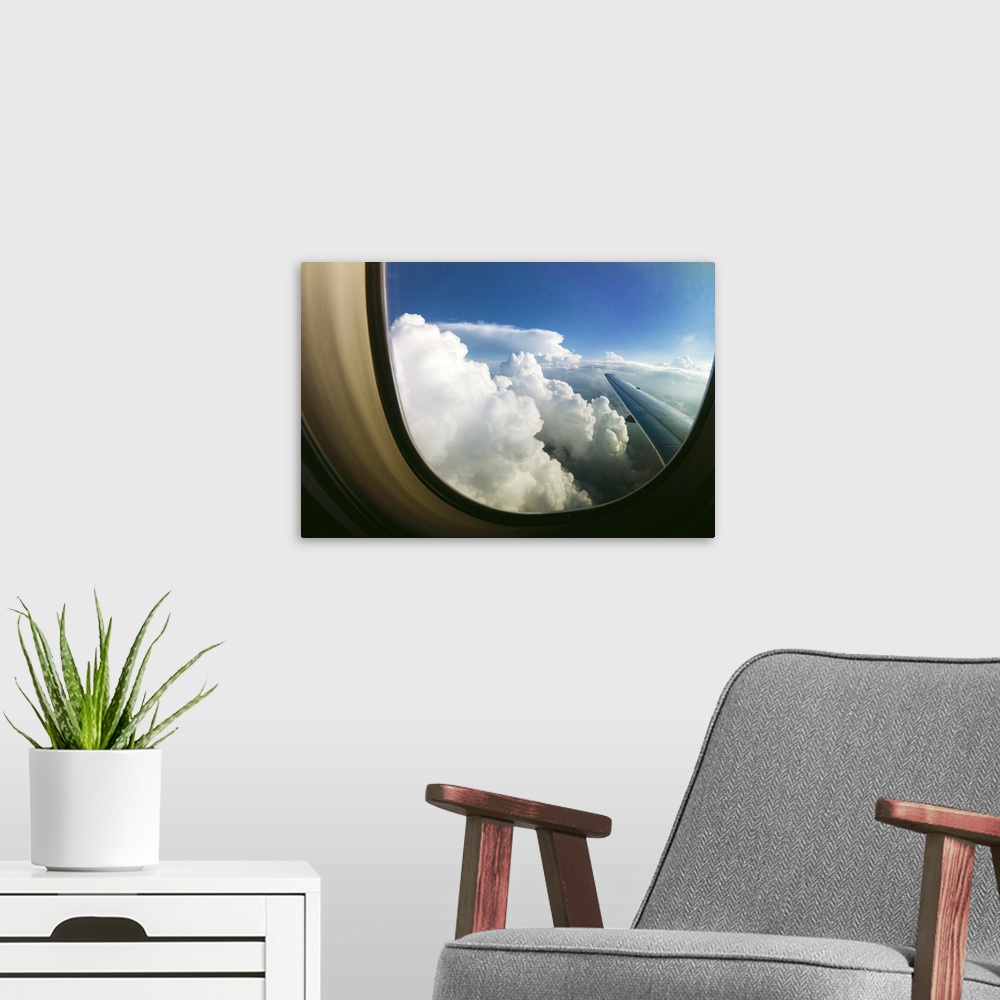 A modern room featuring White fluffy clouds looking through airplane window.