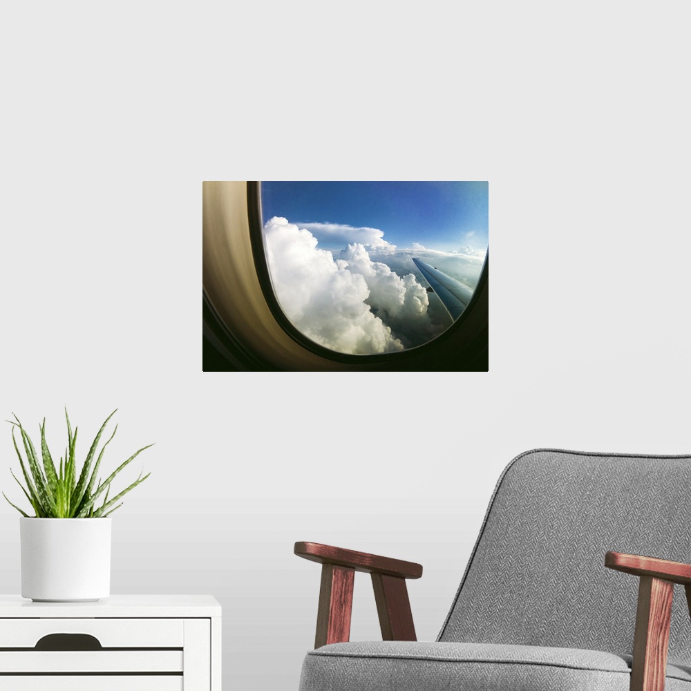 A modern room featuring White fluffy clouds looking through airplane window.