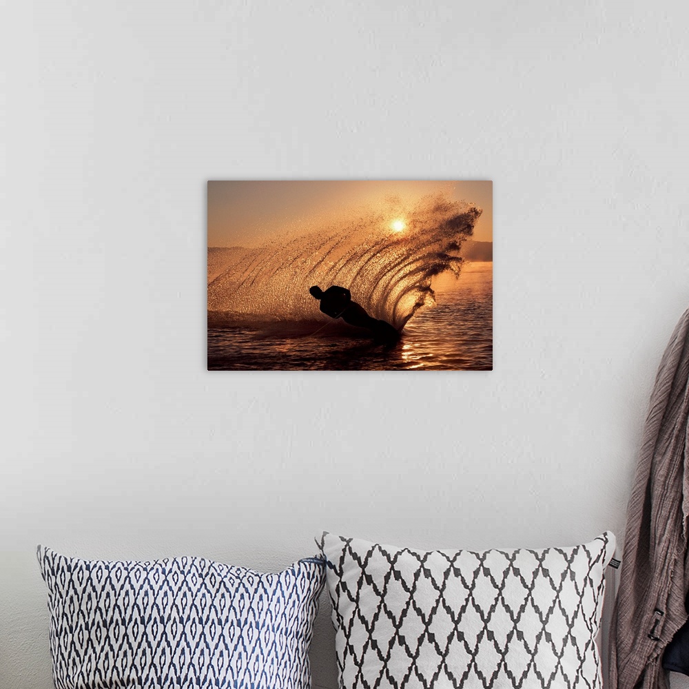 A bohemian room featuring Water-skier at sunset sending up spray of water