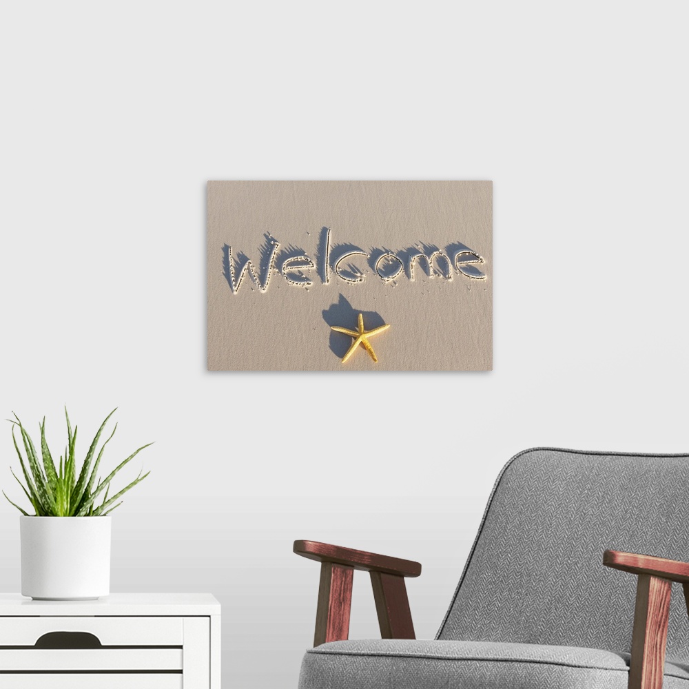 A modern room featuring Welcome written on the sand of a beach. Yellow starfish.
