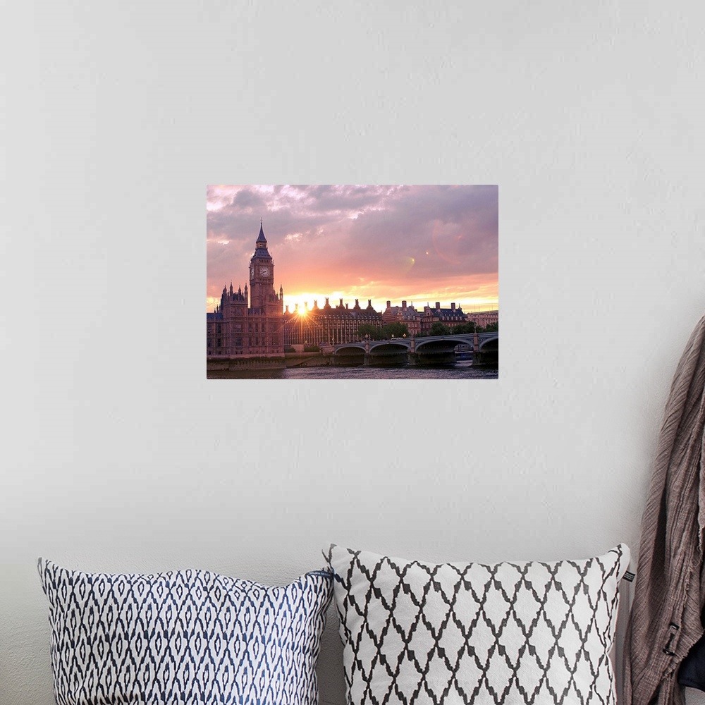 A bohemian room featuring Big photograph shows the sun beginning to set over some of the gothic revival architecture that s...