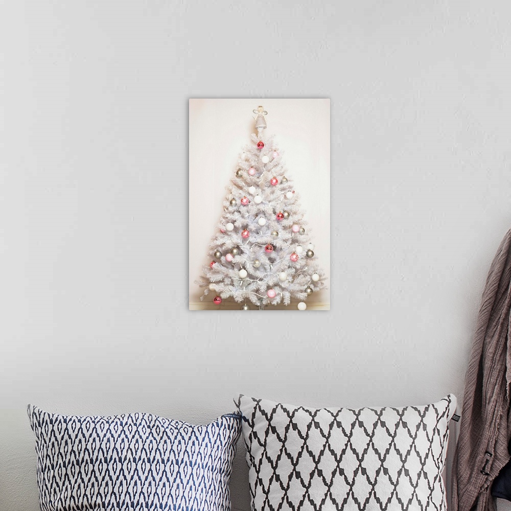 A bohemian room featuring White Christmas tree with baubles and angel on top