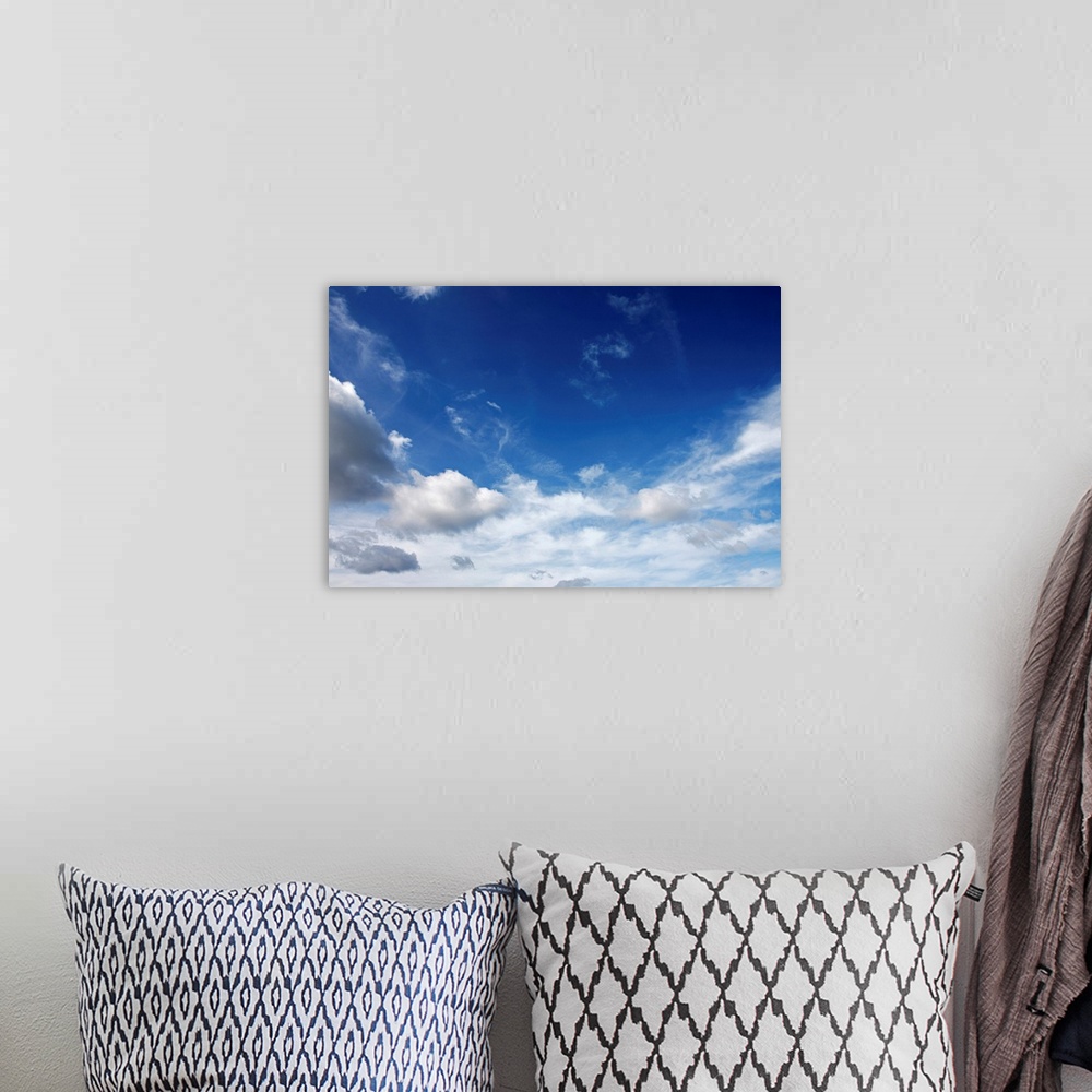 A bohemian room featuring Big canvas photo of lots of fluffy clouds in the sky.