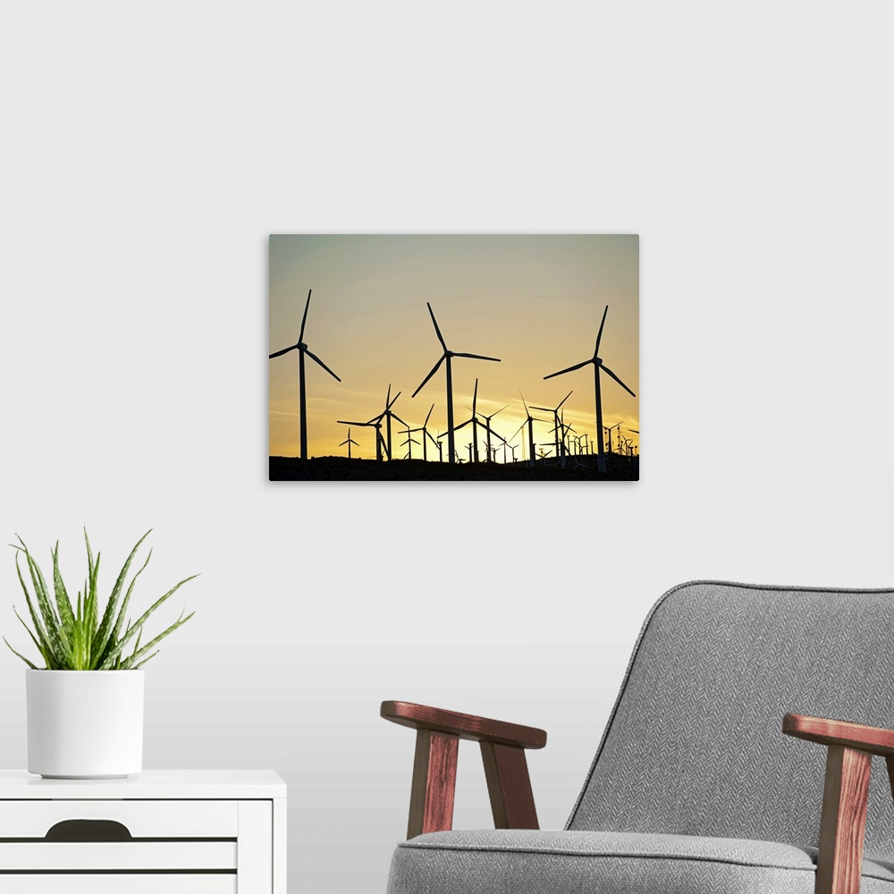 A modern room featuring Wind farm in desert at sunset