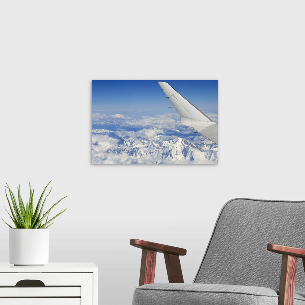 A modern room featuring Wings of flying airplane over French Alps, France, (aerial view)