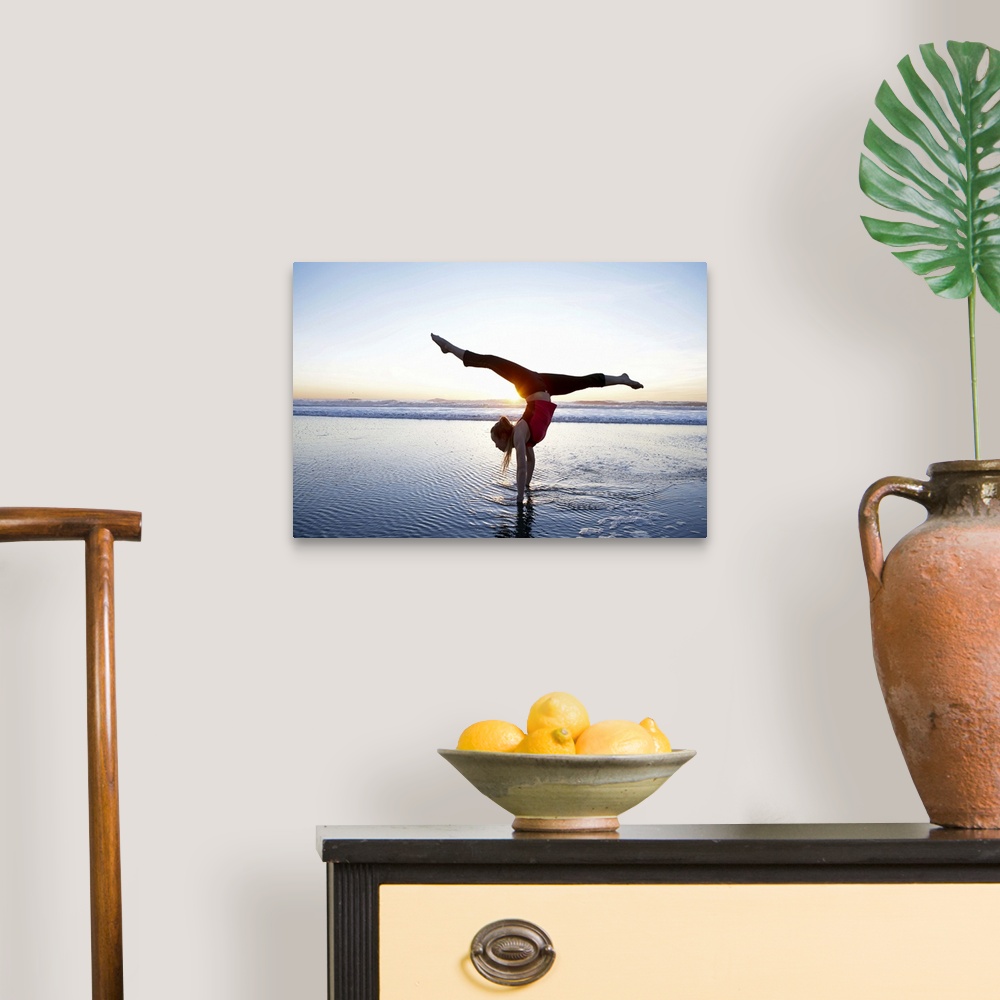 A traditional room featuring Woman doing a hand-stand on the beach at sunset.